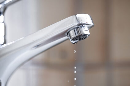 Bathroom faucet with water dripping.
