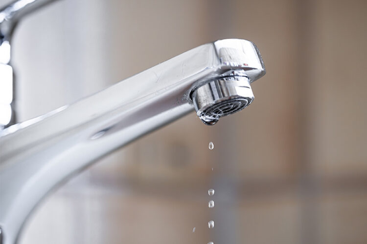 Bathroom faucet with water dripping.