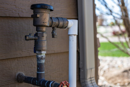 Irrigation system backflow preventer outside of residential home.