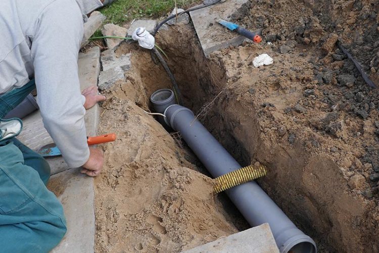 Plumbers installing new PVC sewer line
