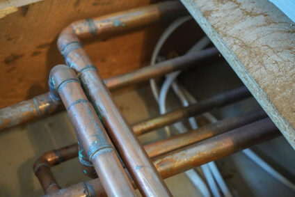 copper plumbing lines exposed under flooring.