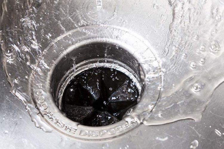 Closeup of sink drain with garbage disposal installed.
