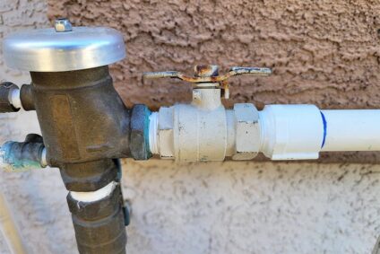 Backflow preventer on residential outdoor plumbing line.