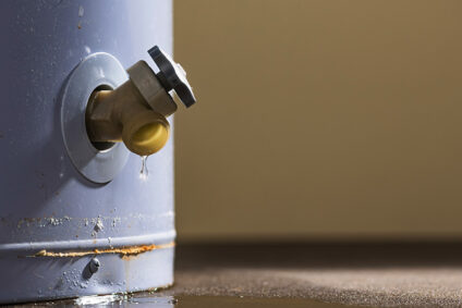 Water leaking from a traditional tank water heater.