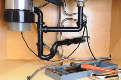 Plumbing tools lying under a garbage disposal.