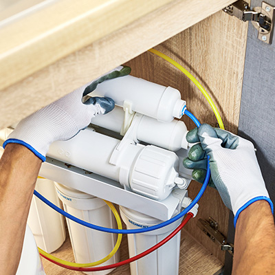 Technician checking connection on RO system.