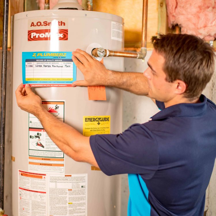 plumber placing service sticker on water heater