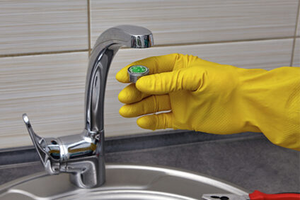 Person installing a new aerator on a sink faucet.
