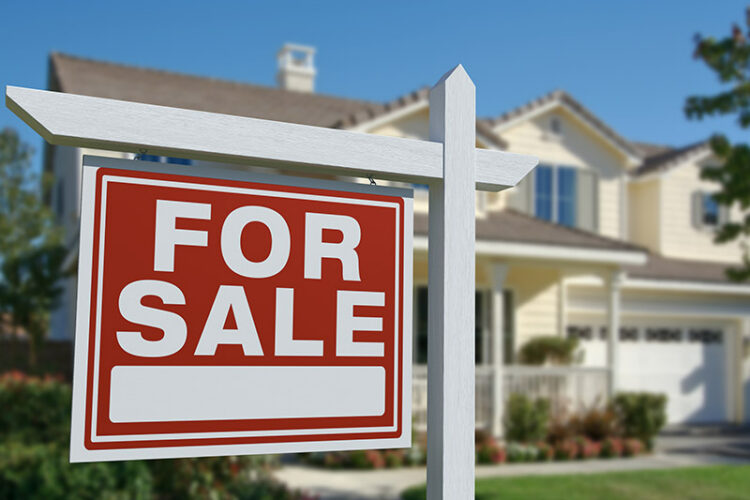For sale sign in front of residential home.