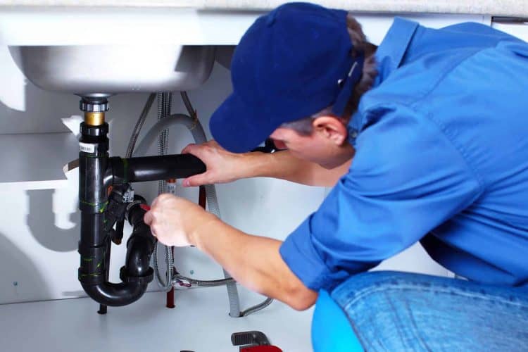 Technician working on kitchen sink