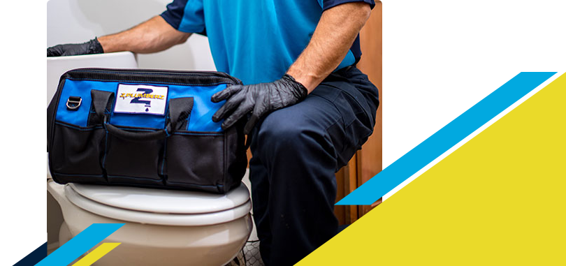 Z PLUMBERZ of Central Long Island technician kneeling with tool bag on toilet